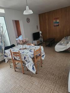 a living room with a table and chairs and a bed at bord de mer in Leucate-Plage