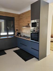 a kitchen with a stove and a microwave at Villa Lila in Cherchell