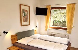 two beds in a room with a window at Ferienwohnungen Petrisberg in Trier