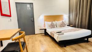 a hotel room with a bed and a desk and a chair at Hotel CINCO PRIME -PREMIUM ROOMS in Secunderabad
