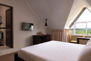 a bedroom with a bed and a window at Oak Ray Misty Hills in Nuwara Eliya