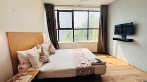 a bedroom with a bed with a window and a television at Hotel CINCO PRIME -PREMIUM ROOMS in Secunderabad