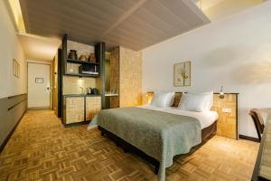 een slaapkamer met een groot bed en een keuken bij Hotel Bleecker by BHC in Bloemendaal