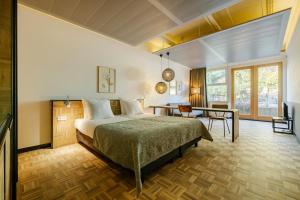 een slaapkamer met een bed en een bureau in een kamer bij Hotel Bleecker by BHC in Bloemendaal