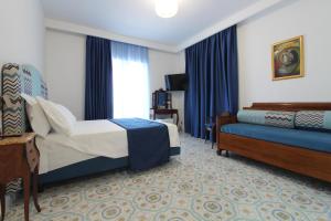 ein Hotelzimmer mit einem Bett und einer Couch in der Unterkunft Paomà in Agropoli