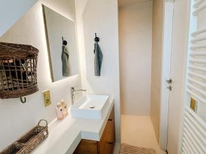 a white bathroom with a sink and a mirror at la MERéMOI - Duplex Knokke with balcony and free parking in Knokke-Heist