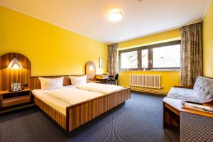 a hotel room with a large bed and a chair at Hotel Grunewald in Berlin +80 photos