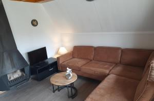 a living room with a couch and a fireplace at De Eekhoorn in Gramsbergen