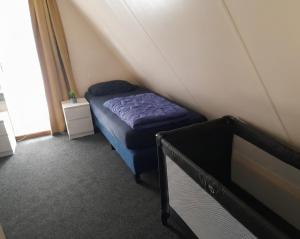 a small bedroom with a blue bed in a attic at De Eekhoorn in Gramsbergen