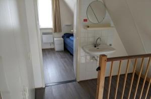 a small bathroom with a sink and a mirror at De Eekhoorn in Gramsbergen +7 photos