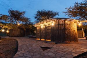 a wooden building with lights on it at night at Bunduz Mara in Sekenani