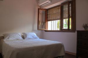 a bedroom with a bed with a window and a mirror at Casa Morotï - Casa de dos habitaciones en la Costanera de Corrientes in Corrientes
