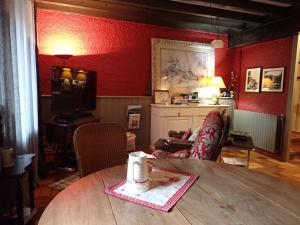 a living room with a table and a red wall at Bramfam in Gresse-en-Vercors