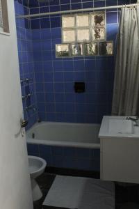 a blue tiled bathroom with a toilet and a sink at Casa Morotï - Casa de dos habitaciones en la Costanera de Corrientes in Corrientes +8 photos