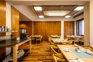 a restaurant with wooden walls and tables and chairs at Hotel Grunewald in Berlin