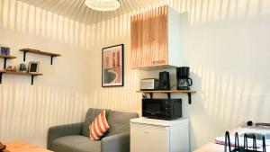 a living room with a couch and a microwave at ZenDay studio proche de Paris in Ivry-sur-Seine