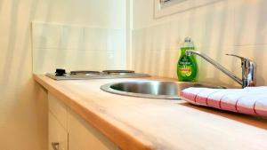 a kitchen counter with a sink and a bottle of soda at ZenDay studio proche de Paris in Ivry-sur-Seine