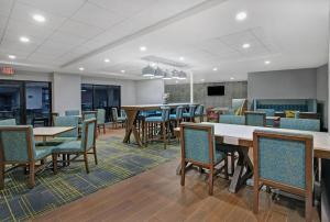 an empty waiting room with tables and chairs at Hampton Inn Westfield in Westfield