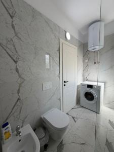a bathroom with a toilet sink and a washing machine at Sunny Hill Residence in Vlorë +54 photos