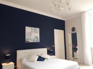 a bedroom with a white bed and a blue wall at Residenza Villa Gorìa in Pontestura