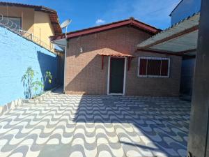 a house with a brick wall and a driveway at Summer House in Ubatuba in Ubatuba