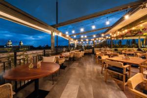 a restaurant with tables and chairs on a balcony at night at Umbral, Curio Collection By Hilton in Mexico City