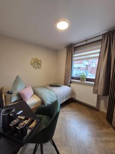 a bedroom with a bed and a desk and a window at STEP IN Apartments ! in Wilhelmshaven
