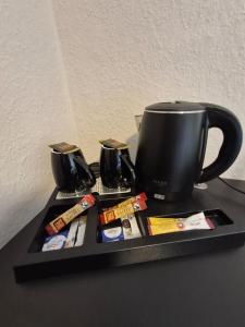 a black tray with a black coffee mug and cinnamon sticks at STEP IN Apartments ! in Wilhelmshaven