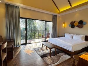 a bedroom with a bed and a balcony at Flower Valley Plantation Homestay in Munnar