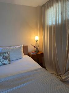 a bedroom with a bed and a lamp and a window at Danube River Cottage - Bezdan in Bezdan