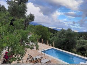 a swimming pool in a garden with chairs and trees at Mathilda's House in Tselendáta