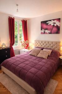 a bedroom with a large purple bed with red curtains at Grand appartement 5 pers avec parking proche du centre ville de Toulouse in Toulouse