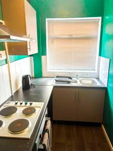 a small kitchen with a stove and a sink at New Hampton Units in Wolverhampton +12 photos