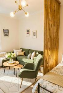 a living room with a green couch and a table at The Velvet Stay in Tbilisi City