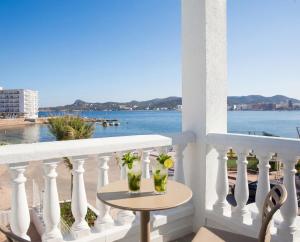 two vases on a balcony with a view of the water at ENDLSS BEACH & DISCO HOTEL IBIZA Adults Only in San Antonio Bay