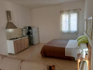 a bedroom with a bed and a couch and a kitchen at Il rifugio dello scultore in Niscemi