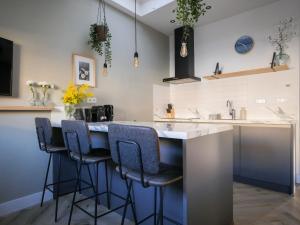 a kitchen with a bar with stools and a counter at Hosted by Wendy Prins Willem 3 in Scheveningen
