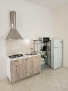 a kitchen with a stove and a refrigerator at Il rifugio dello scultore in Niscemi