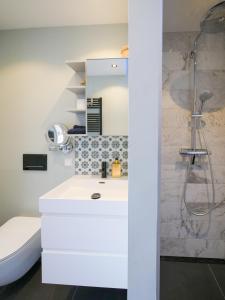 a bathroom with a white sink and a shower at Hosted by Wendy Prins Willem 3 in Scheveningen +42 photos