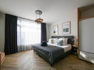 a bedroom with a bed and a large window at Hosted by Wendy Prins Willem 3 in Scheveningen