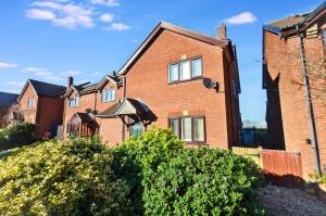 a red brick house with bushes in front of it at 18 Marriotts Way in Sheringham