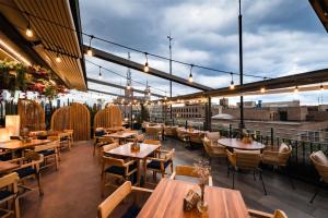 a restaurant with wooden tables and chairs and lights at Umbral, Curio Collection By Hilton in Mexico City