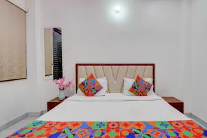 a bedroom with a bed with colorful pillows at FabHotel Metro Inn in Kānpur