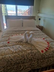two swans made out of towels on a bed at Elysium House in Salamina