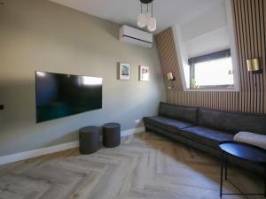 a living room with a couch and a flat screen tv at Hosted by Wendy Prins Willem 3 in Scheveningen