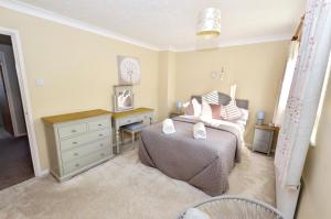 a bedroom with a bed and a desk and a bed and a chair at 18 Marriotts Way in Sheringham