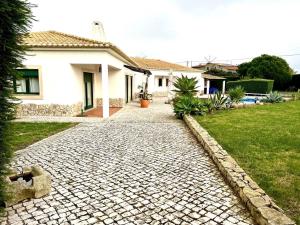 a cobblestone driveway in front of a house at Villa Mar & Surf • Piscina privada in Atouguia da Baleia