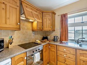 a kitchen with wooden cabinets and a stove top oven at 2 Bed in Alford oc-92252 in Rigsby +13 photos