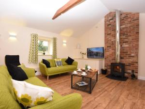 a living room with a green couch and a fireplace at 3 Bed in Alford oc-55963 in Rigsby