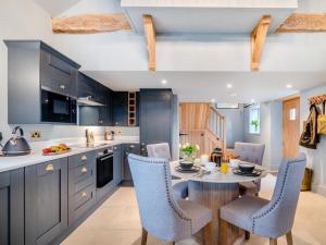 a kitchen with blue cabinets and a table and chairs at 1 Bed in Gloucester oc-95793 in Tirley